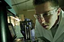 Аспирант Брент Кэри помещает кусочек композита в испытательное устройство. 