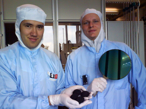 Тим и Макс держат кремниевую вафлю с нанотранзисторами